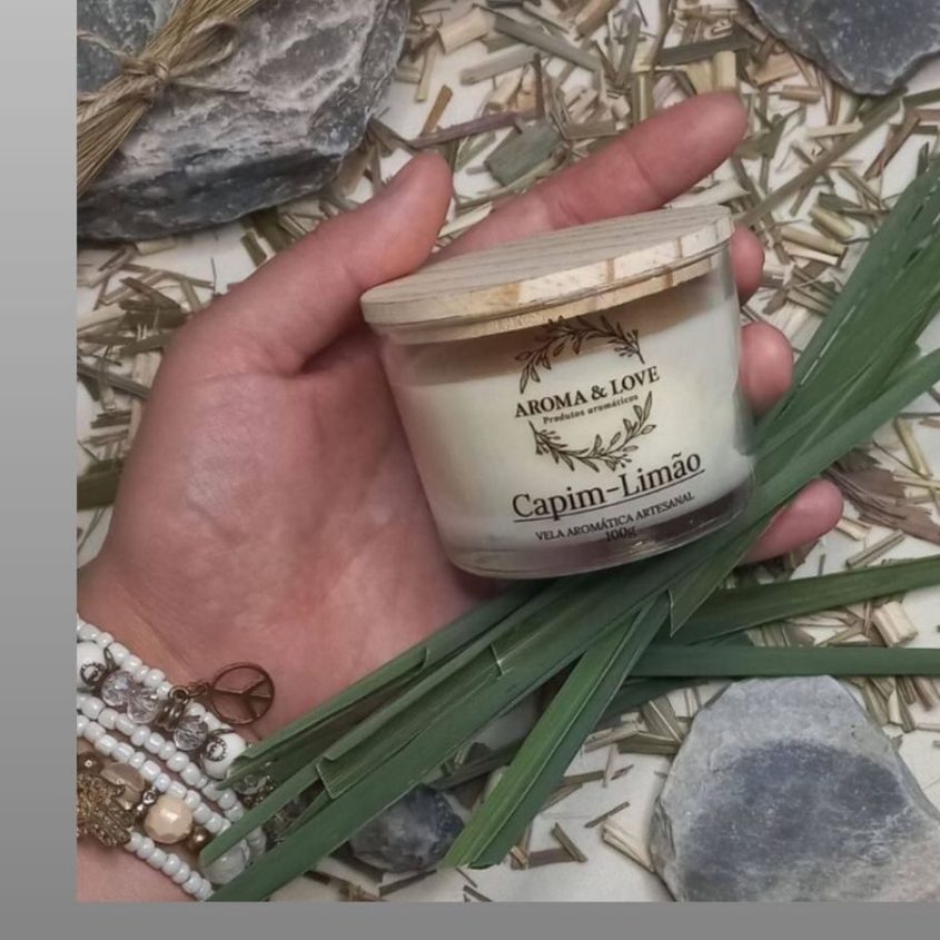Vela Capim-Limão da marca Aroma & Love, sobre folhas e pedras