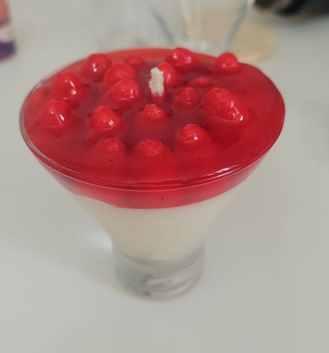 Vela Gourmet de morangos vermelhos sobre cera branca em recipiente cônico